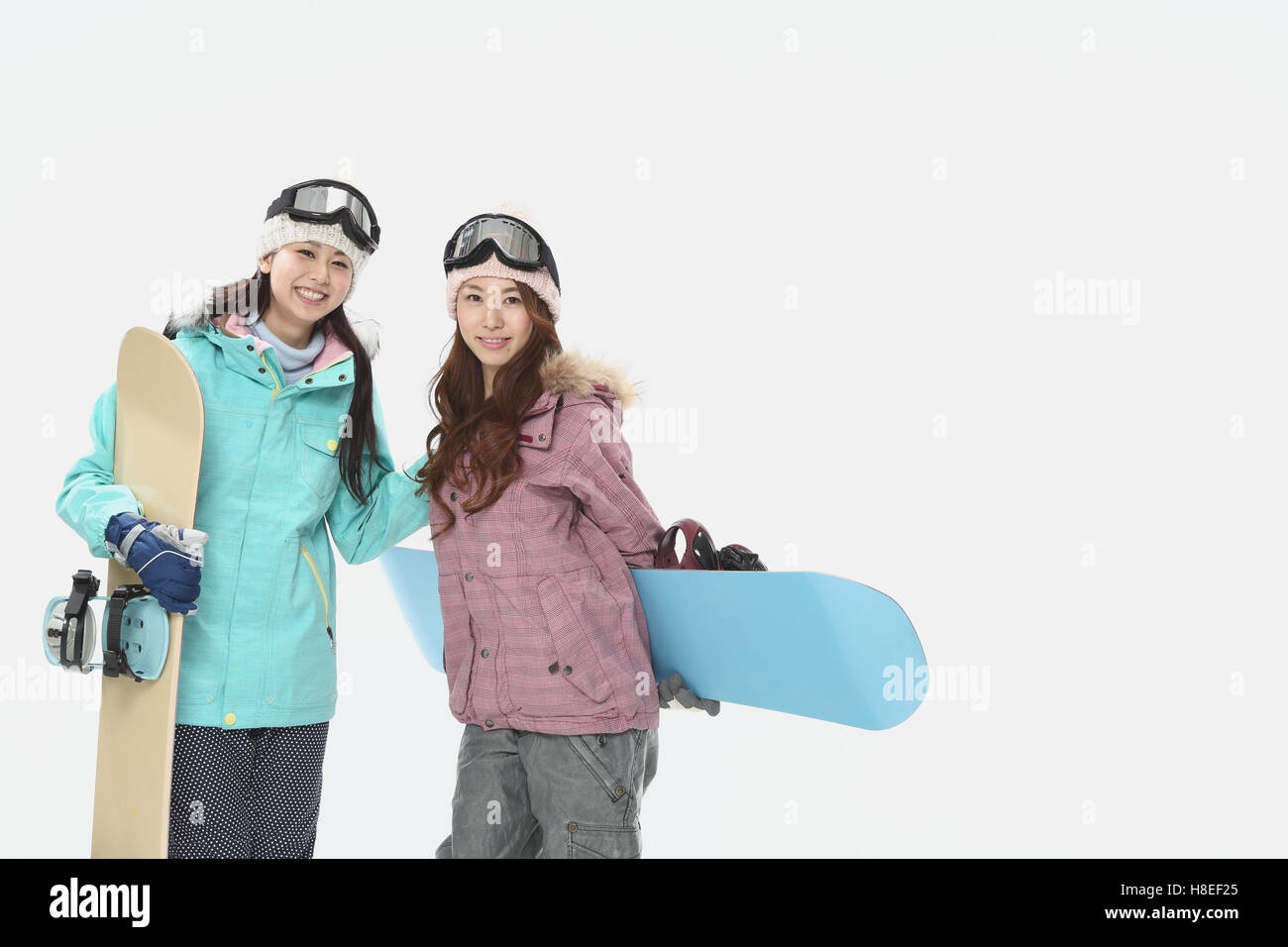 Young Japanese women wearing snowboard wear on white background Stock