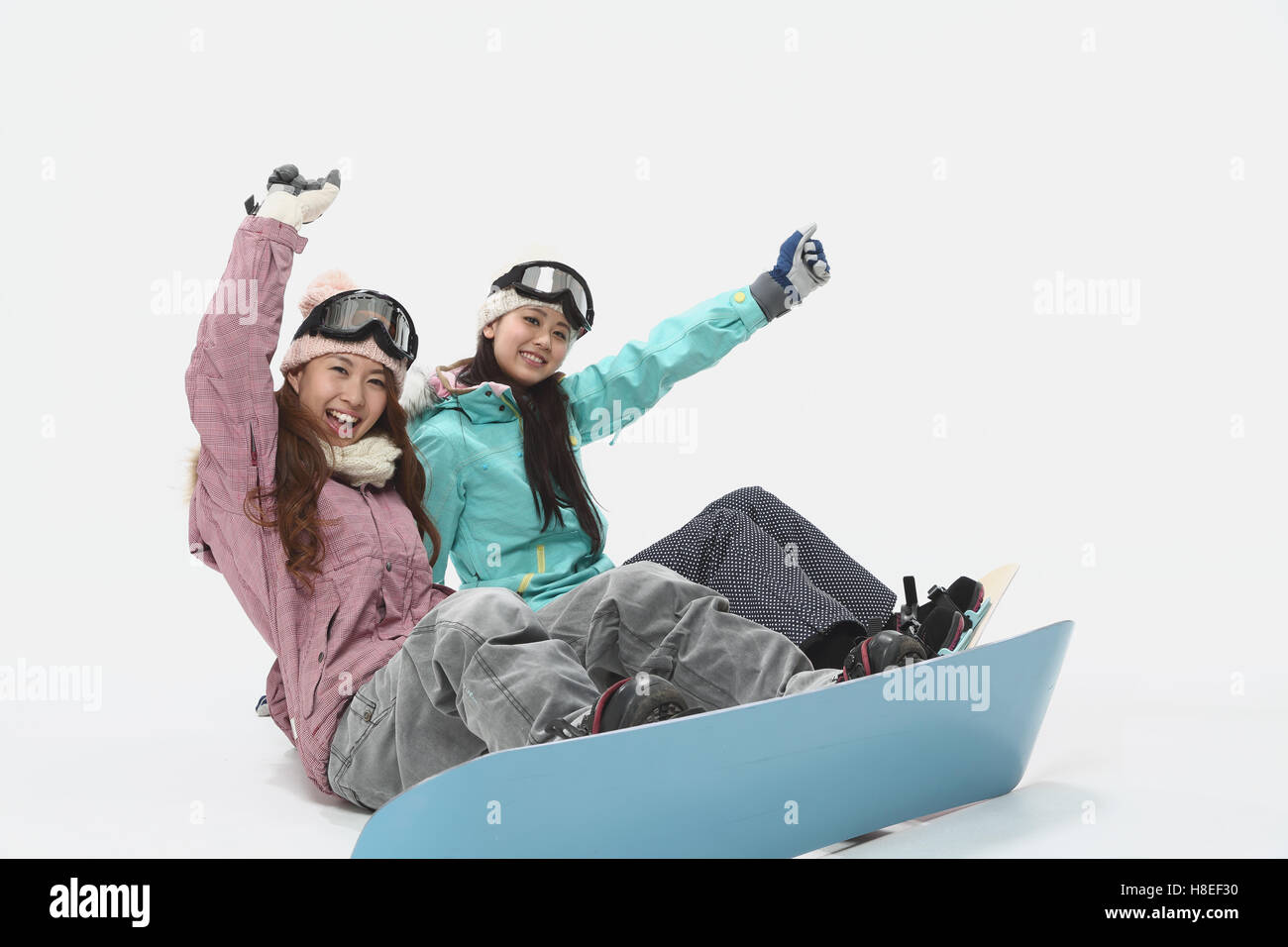 Young Japanese women wearing snowboard wear on white background Stock
