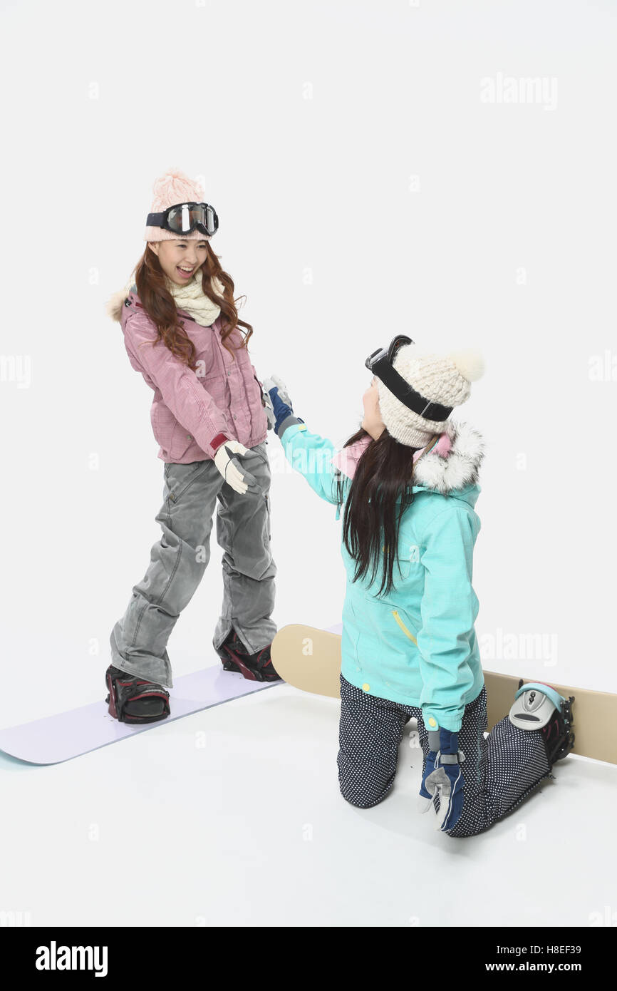 Young Japanese women wearing snowboard wear on white background Stock