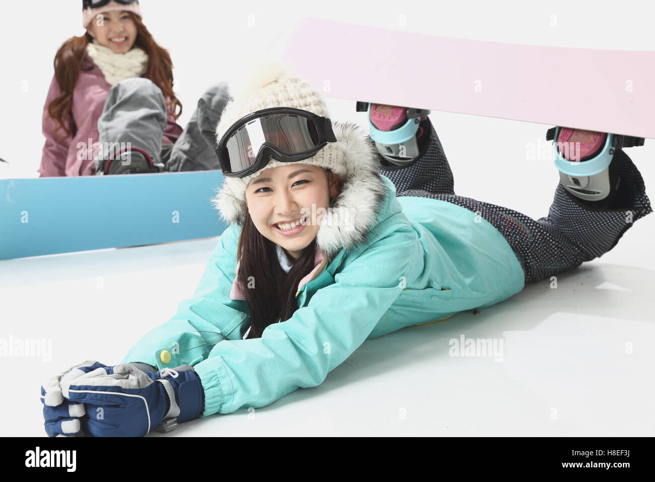 Young Japanese women wearing snowboard wear on white background Stock
