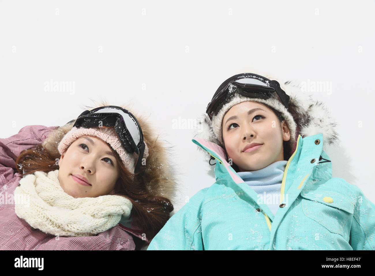 Young Japanese women wearing snowboard wear on white background Stock