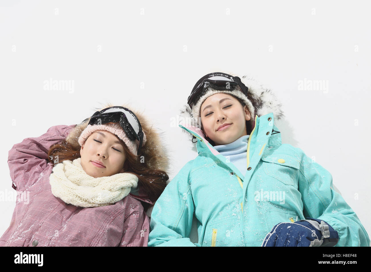 Young Japanese women wearing snowboard wear on white background Stock