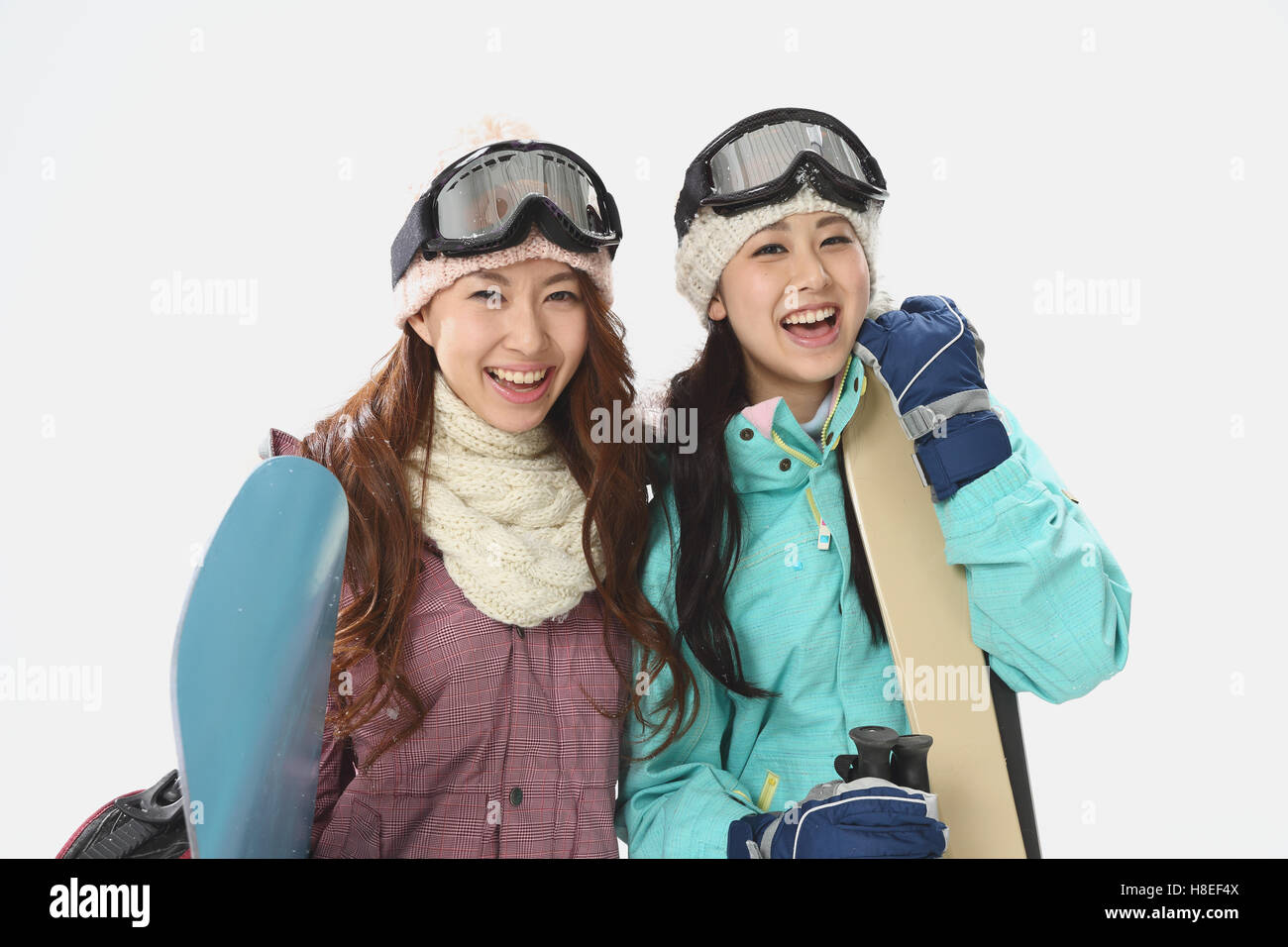 Young Japanese women wearing snowboard wear on white background Stock