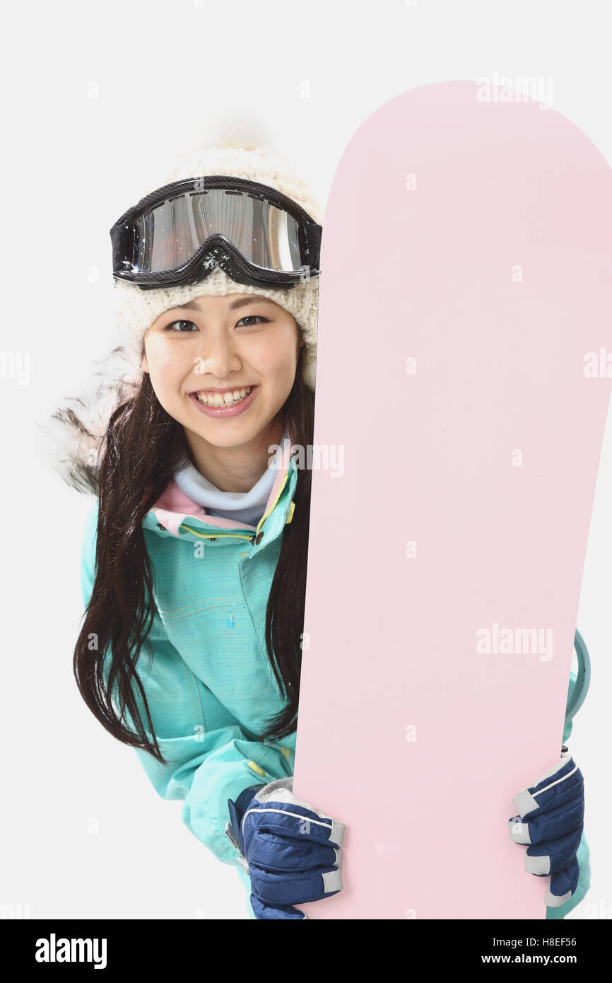Young Japanese woman wearing snowboard wear on white background Stock