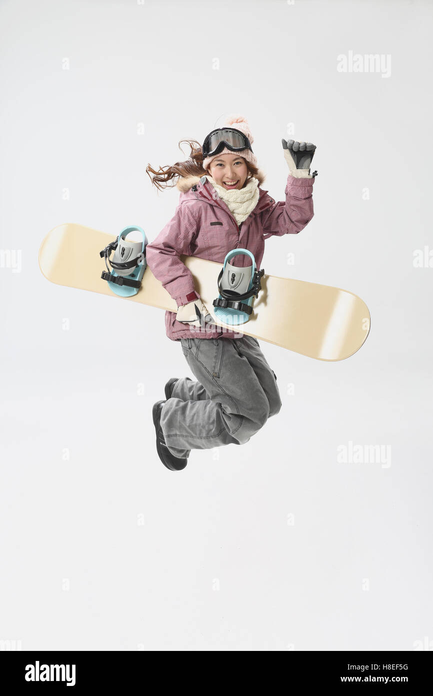 Young Japanese woman wearing snowboard wear on white background Stock