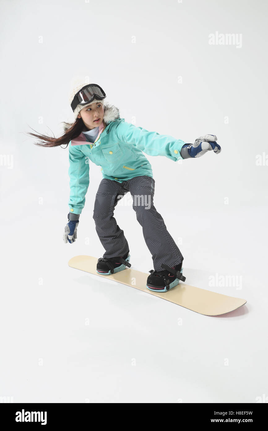 Young Japanese woman wearing snowboard wear on white background Stock