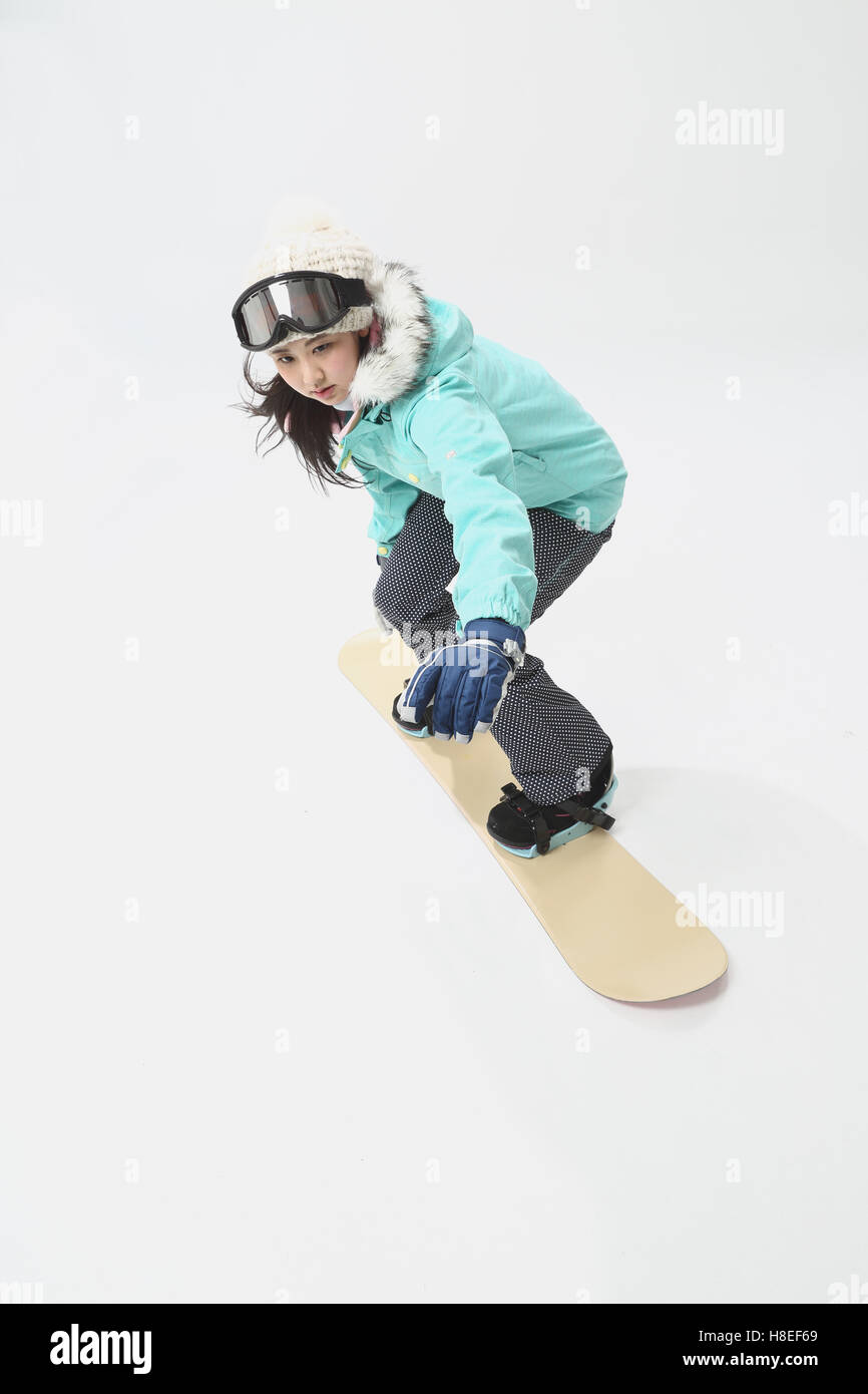 Young Japanese woman wearing snowboard wear on white background Stock