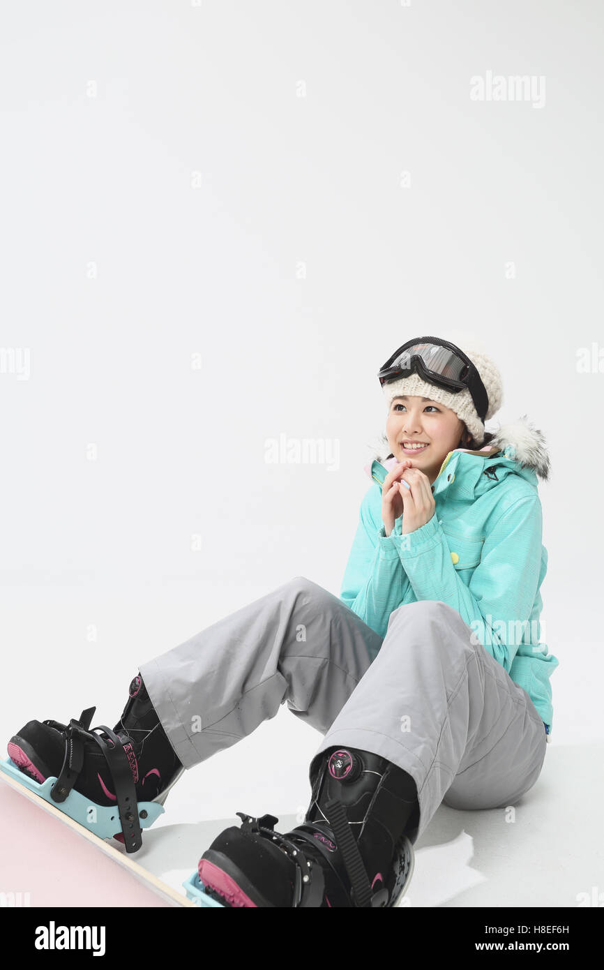 Young Japanese woman wearing snowboard wear on white background Stock