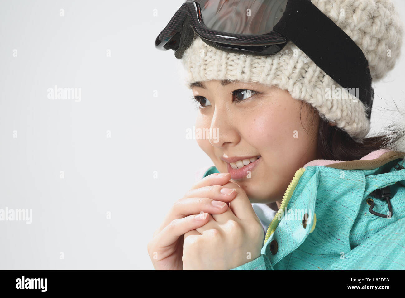 Young Japanese woman wearing snowboard wear on white background Stock
