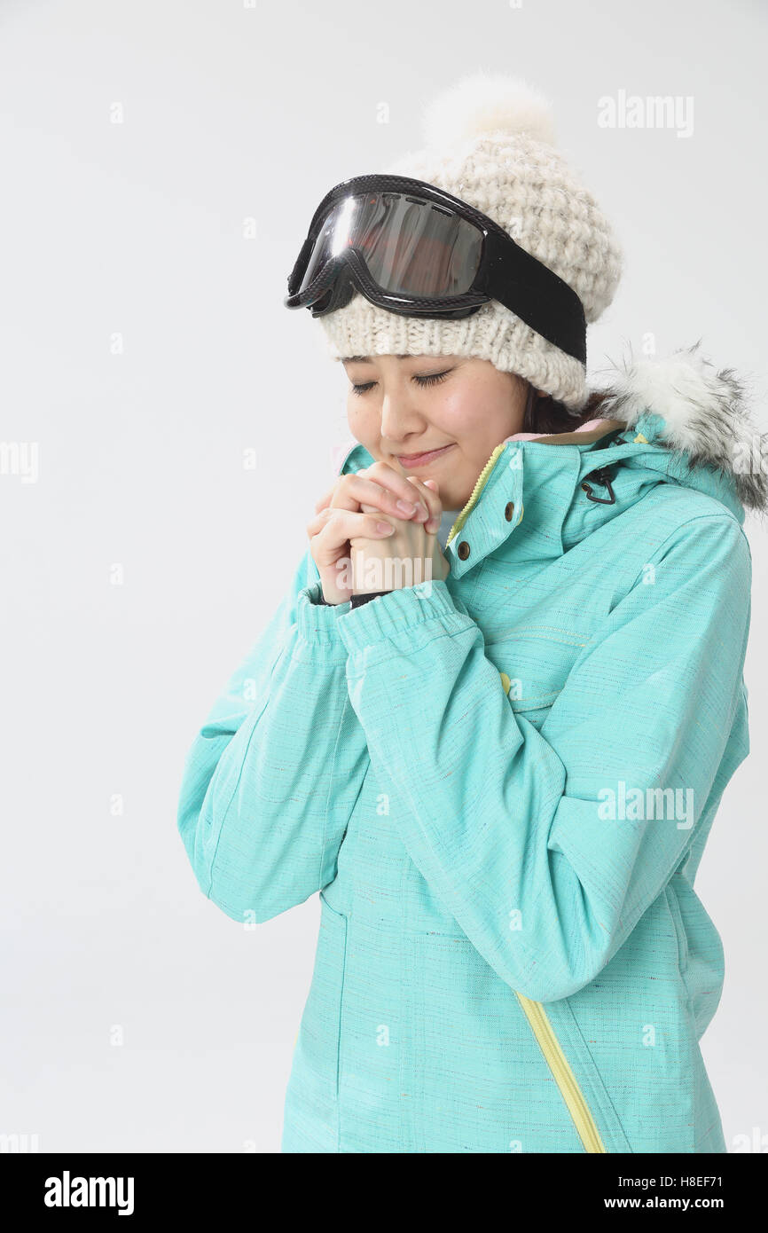 Young Japanese woman wearing snowboard wear on white background Stock