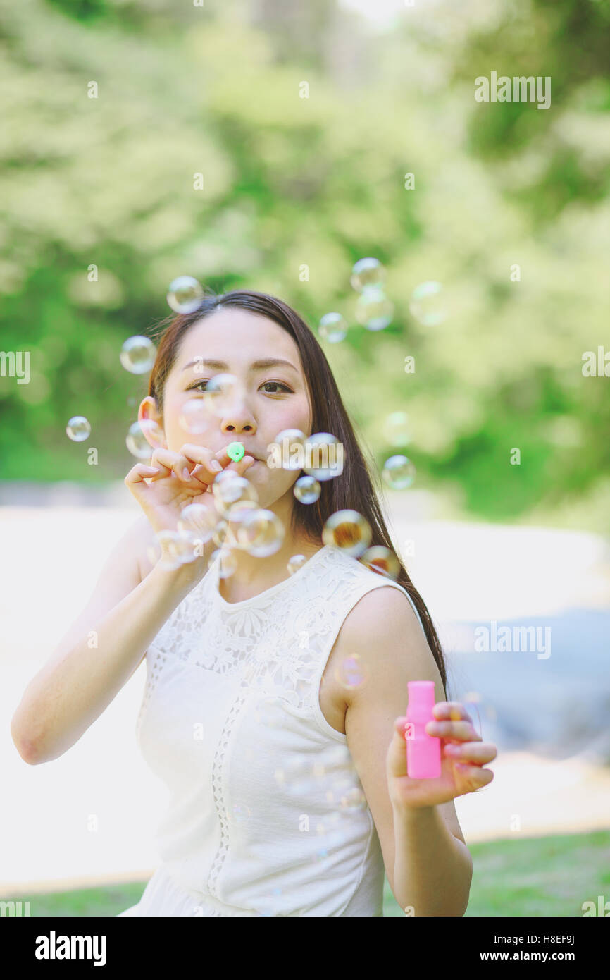 Woman blowing bubbles looking at camera hires stock photography and