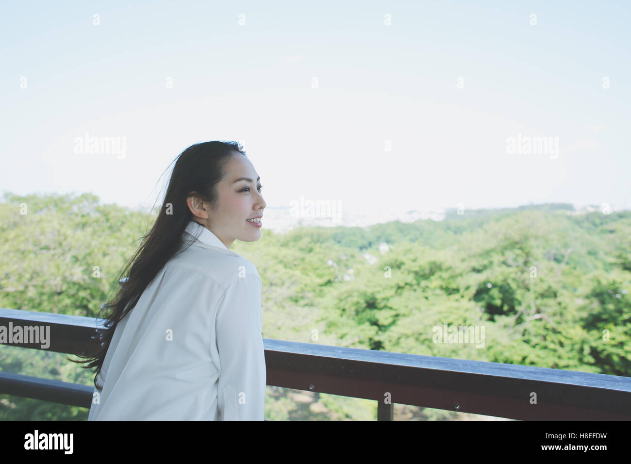Young Japanese woman at observation deck in a city park Stock Photo