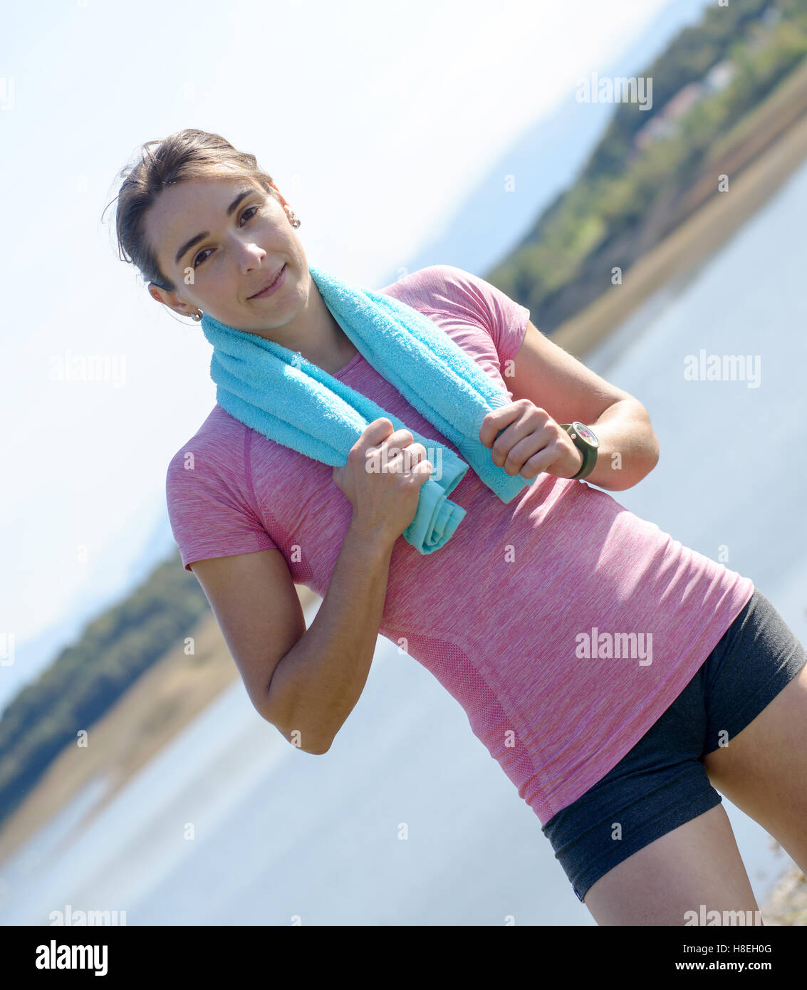 portrait of young sporty woman with blue towel in the countryside Stock ...