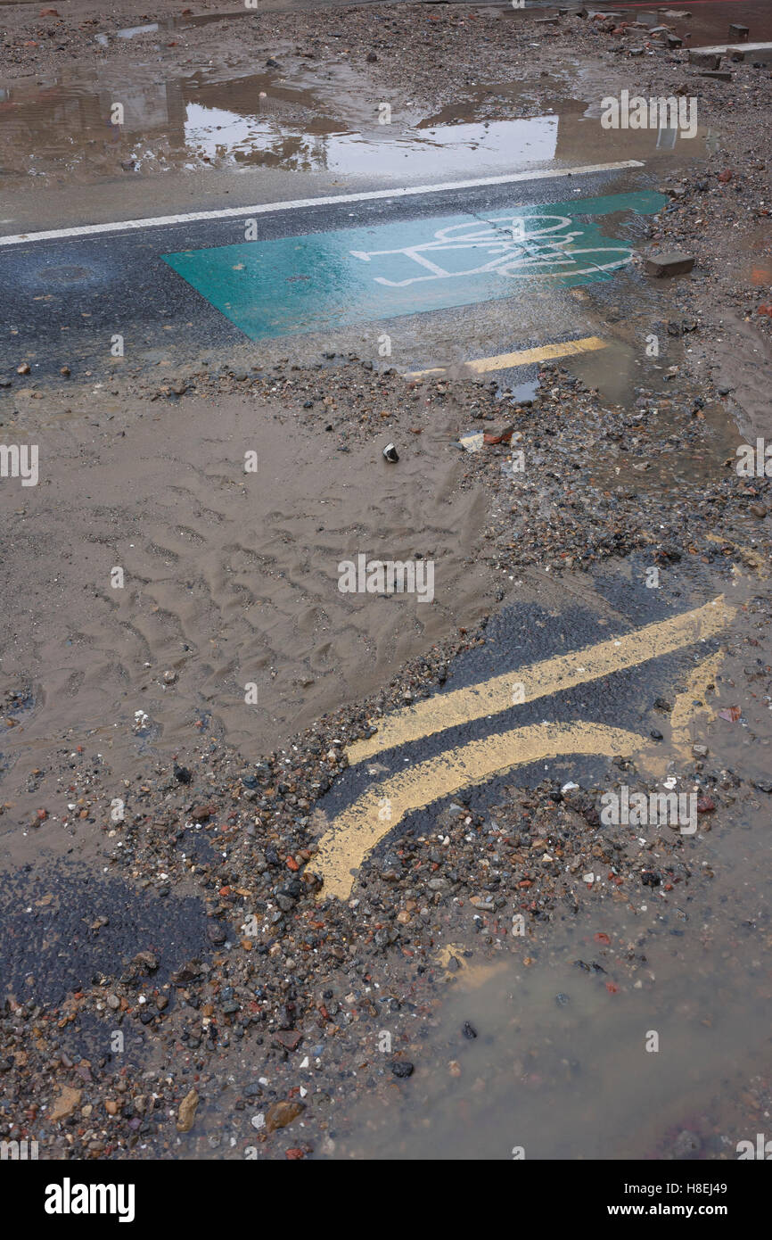 Waters subside leaving a mess of silt and stones after a main water main burst on Camberwell New Road, Southwark, London. Stock Photo