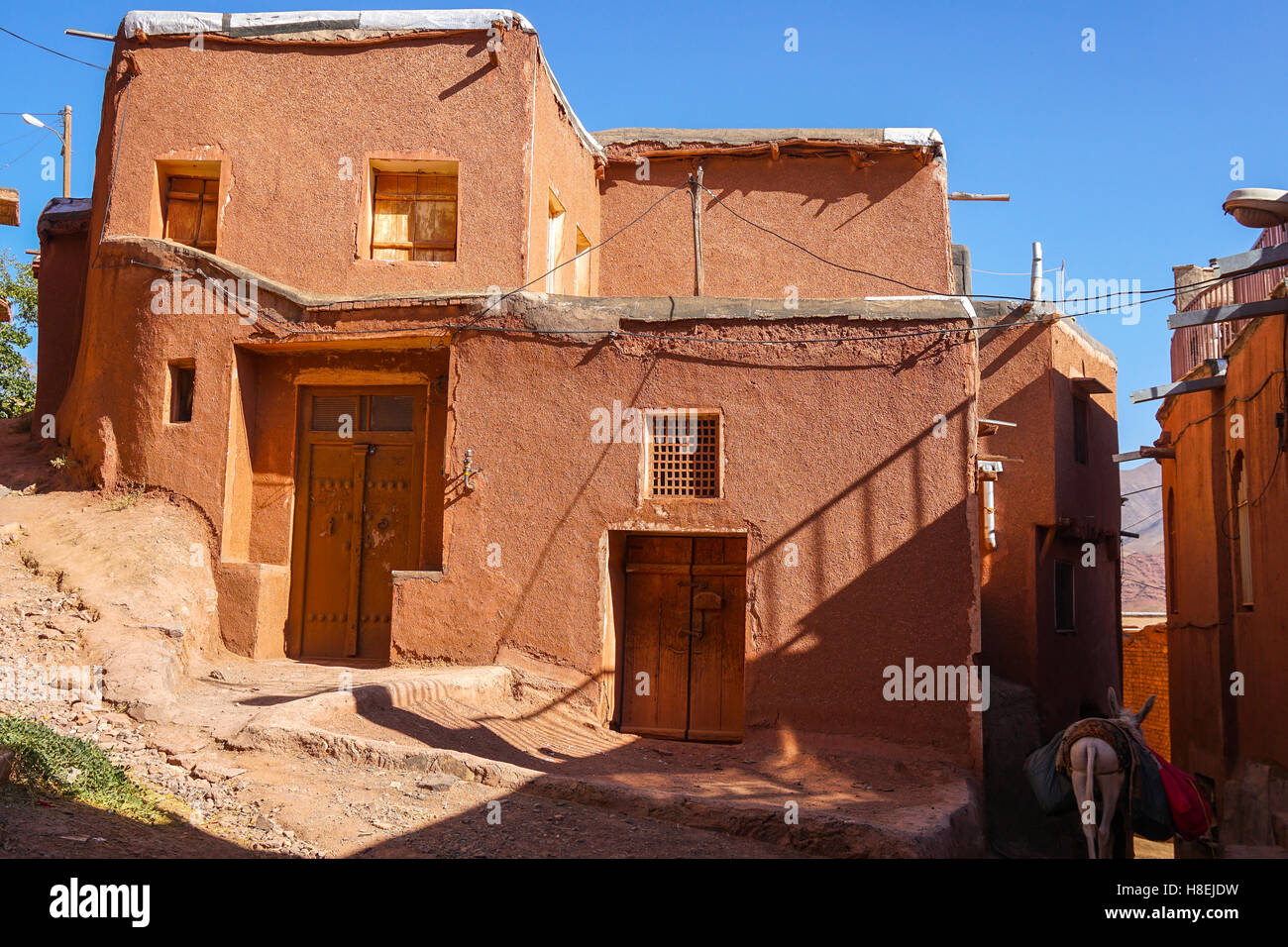 Winding lanes and donkey in 1500 year old traditional village of red mud brick houses, Abyaneh, Iran, Middle East Stock Photo