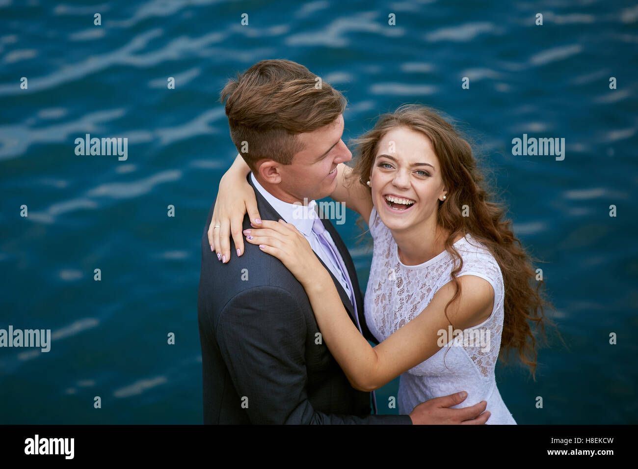 bride and groom hugging at the background of water Stock Photo