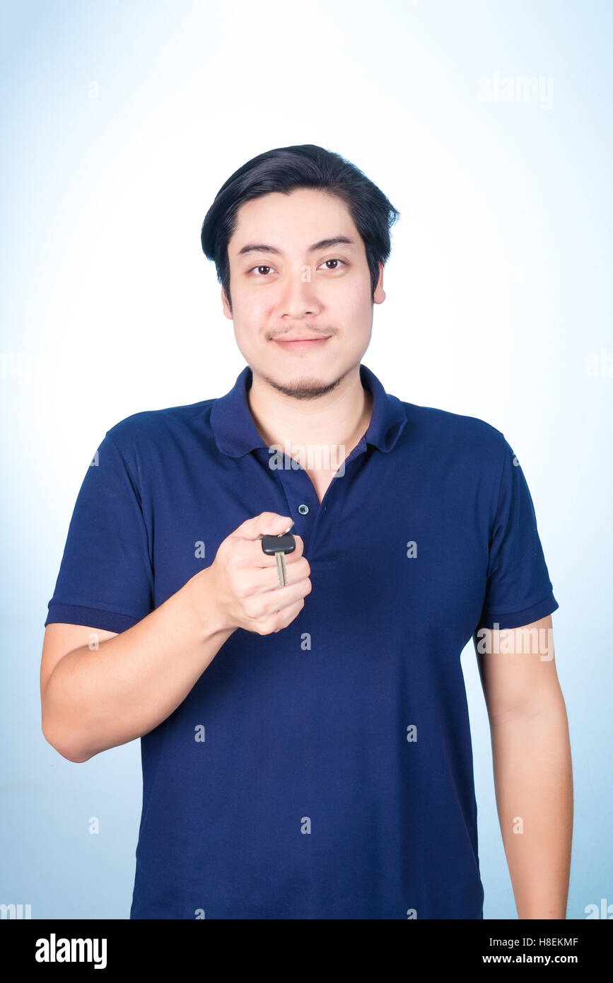Asian handsome man holding, showing the keys of his new car, on blue ...