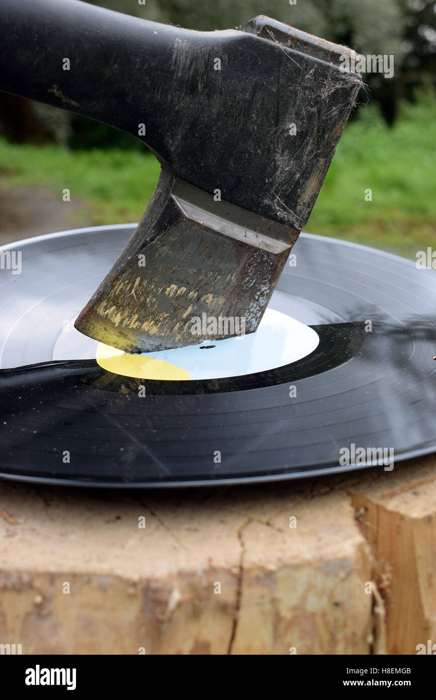 Destroying vinyl record with an ax. Stock Photo