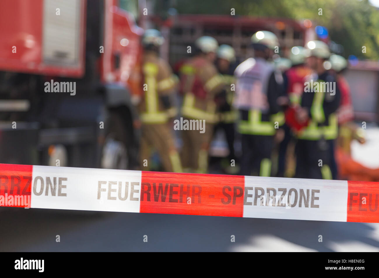 Team of firefighters by firetruck on accident location. Stock Photo