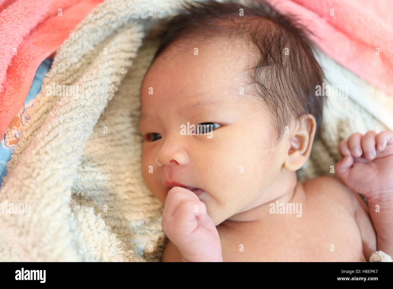 suspicious baby boy facial expressions on the bed,Asian boy in Thailand. Stock Photo