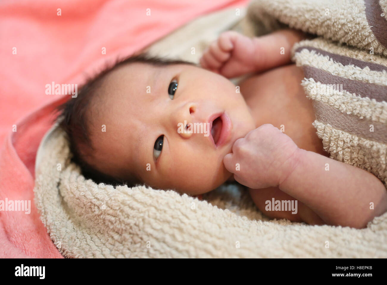 suspicious baby boy facial expressions on the bed,Asian boy in Thailand. Stock Photo