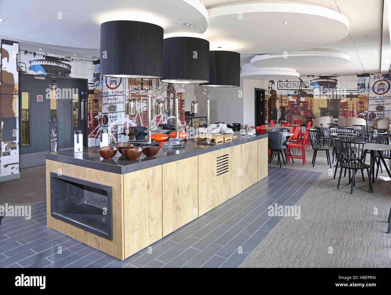Breakfast self-service and seating area in the new Ibis Hotel in Cambridge, UK. Shows serving dishes and crockery prior to use. Stock Photo