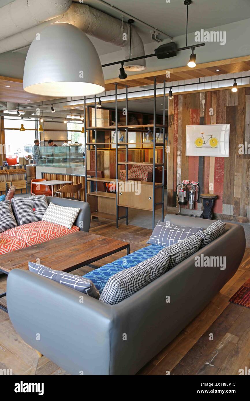 Lounge and reception area in a new Ibis Hotel in Cambridge, UK. Shows vintage style sofas, tables and shelves Stock Photo