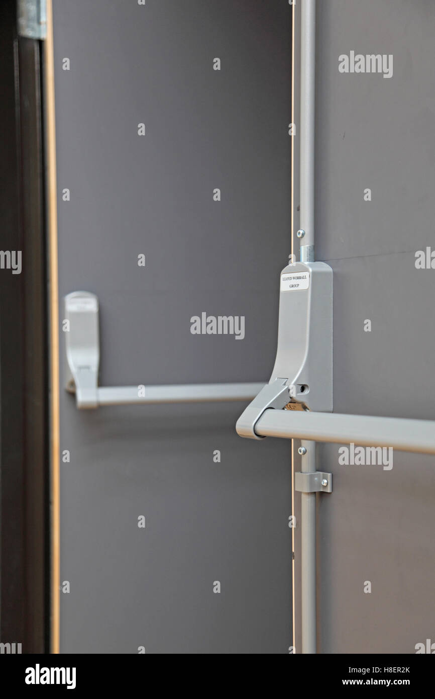 Closeup of a fire escape door in a modern London school. Shows detail of push-bar and panic bolt system Stock Photo
