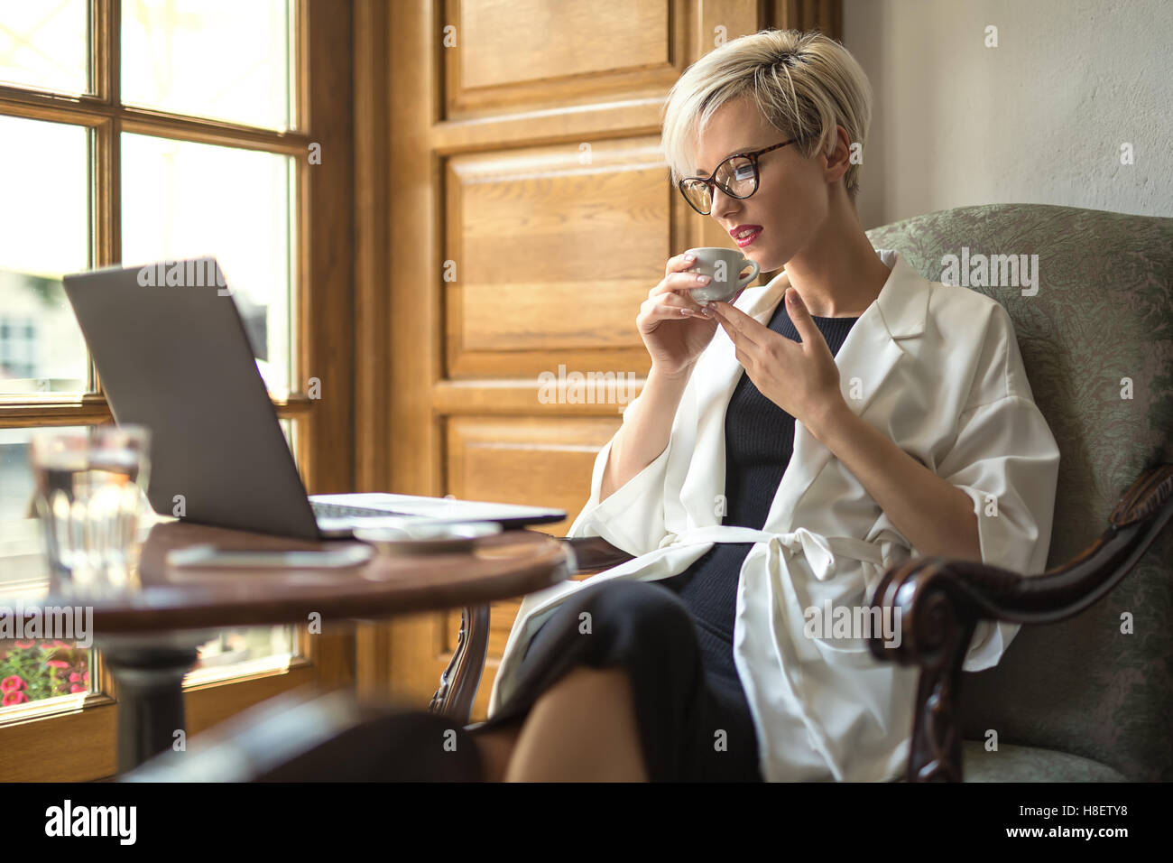 Girl with laptop and cup in cafe Stock Photo