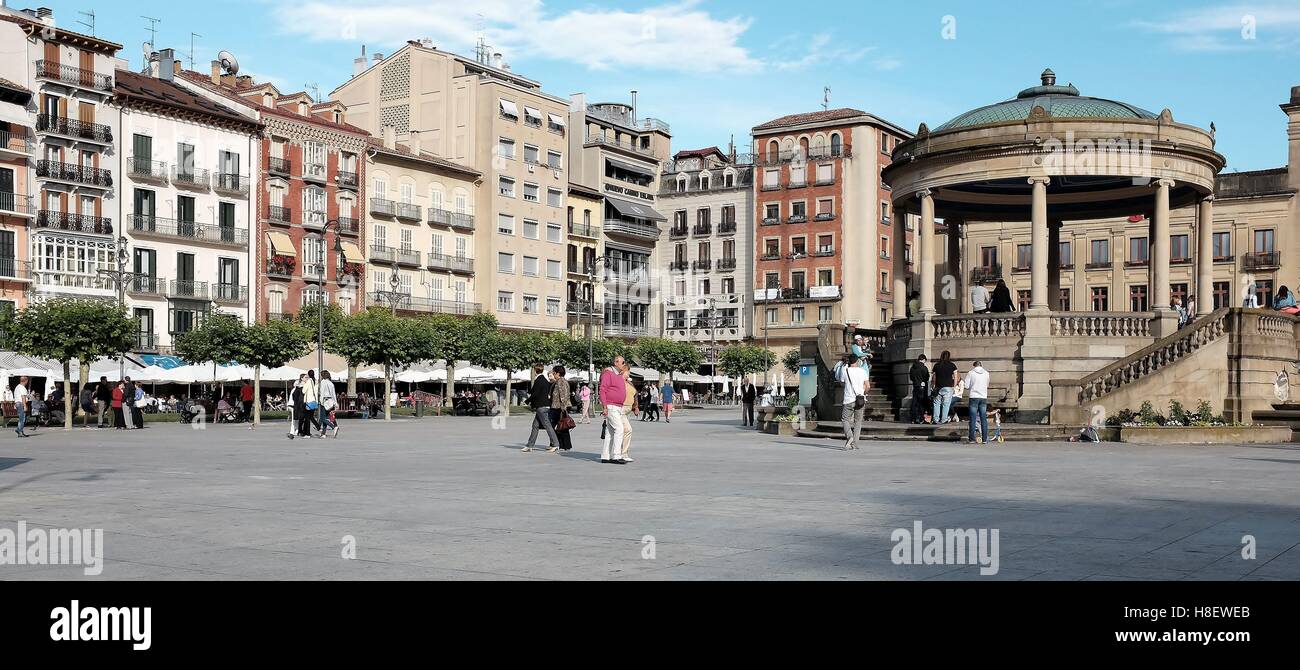 People take to the large historic Plaza del Castillo in Pamplona, Spain on a sunny June day in 2015. Castillo Square has a rich history. Stock Photo