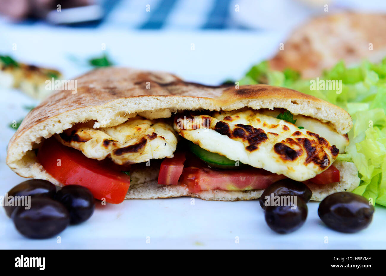 Traditional Cypriot pita sandwich with grilled halloumi and vegetables. Stock Photo