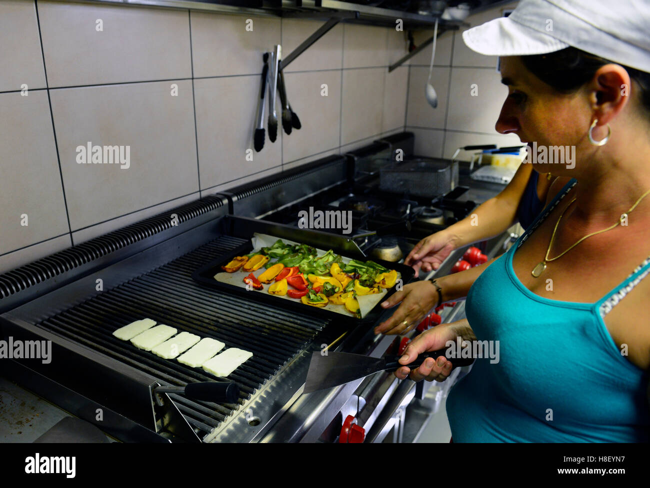 Grilling halloumi cheese In Il Castelo restaurant in Limassol. Stock Photo