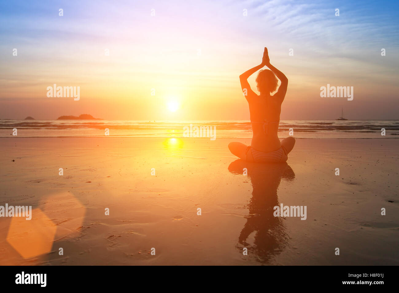 Female silhouette in yoga Lotus pose on the beach during an awesome ...