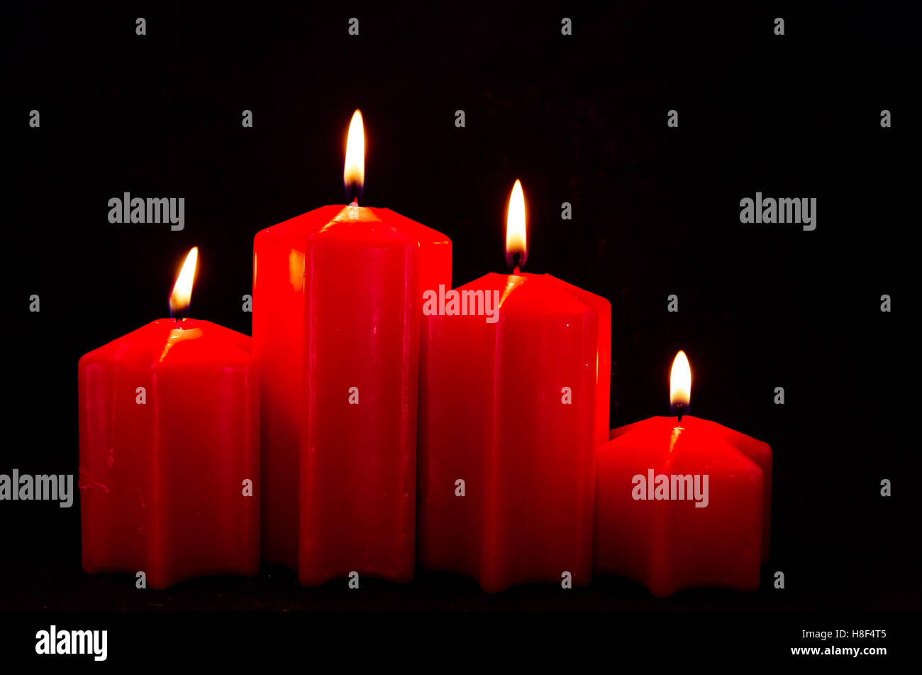 burning red advent candles with black background Stock Photo Alamy