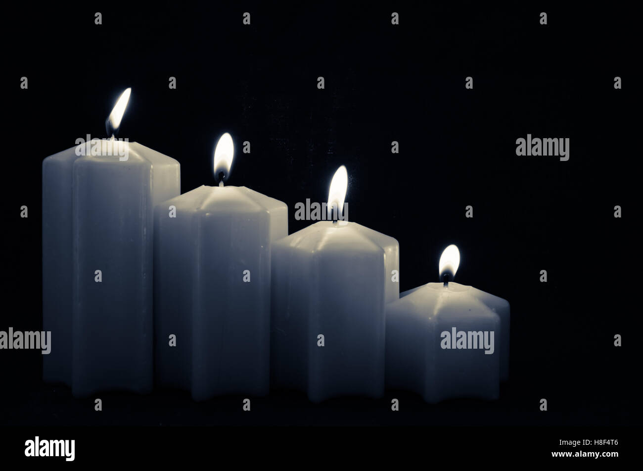 four burning gray advent candles with black background Stock Photo Alamy