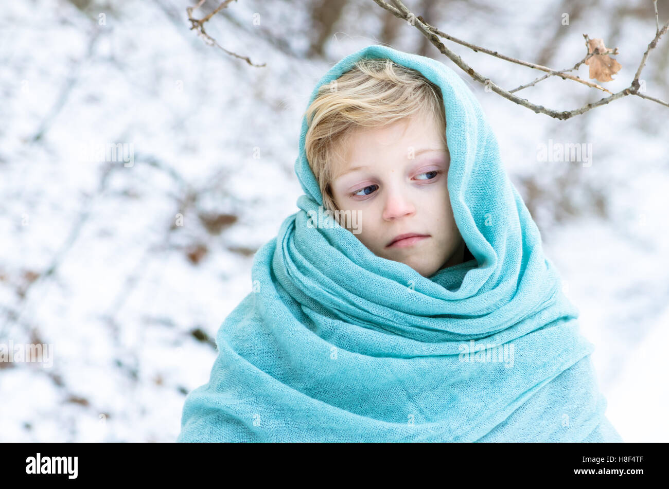 lovely blond child with blue scarf outdoor in winter time Stock Photo