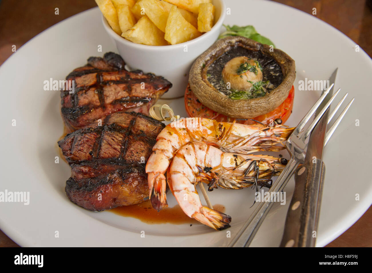 Surf & turf, steak served with prawns, chips and mushrooms. a UK food seafood Stock Photo