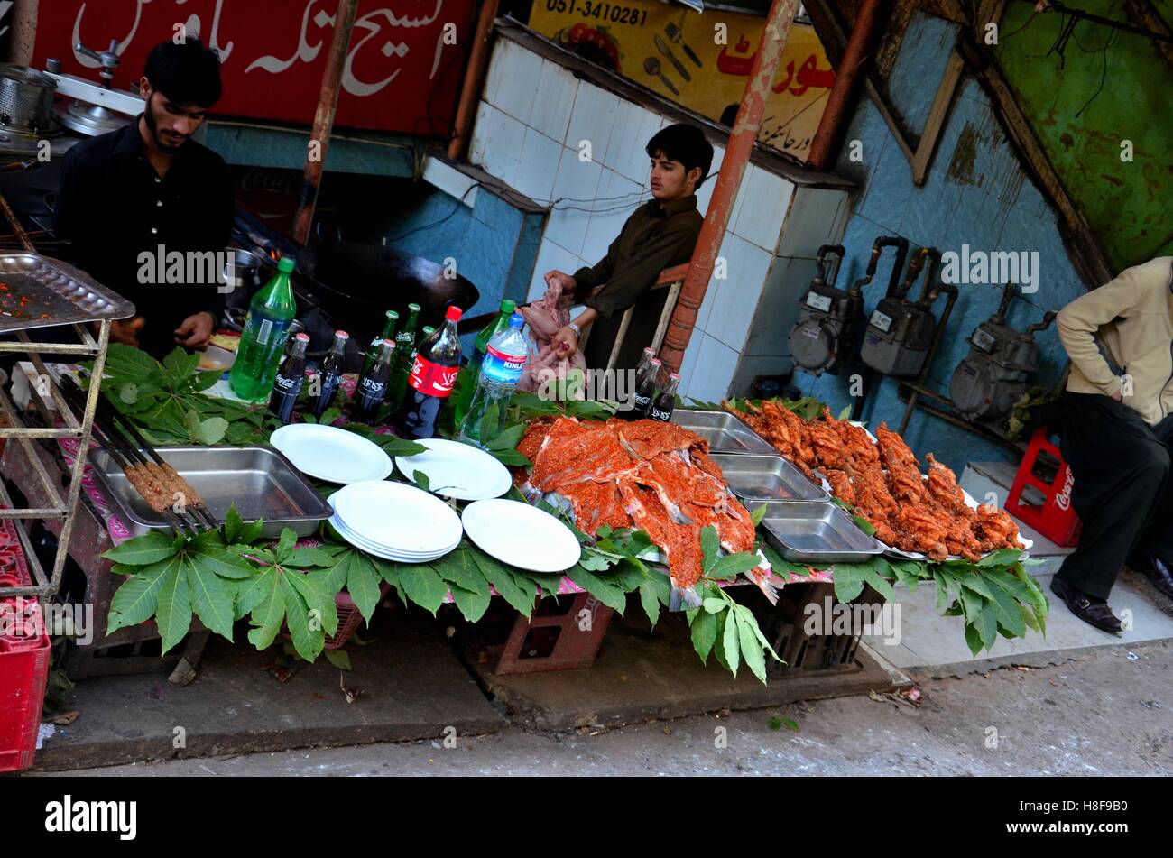 Men at street side restaurant with marinated meat on tree leaves displayed at Murree Pakistan Stock Photo