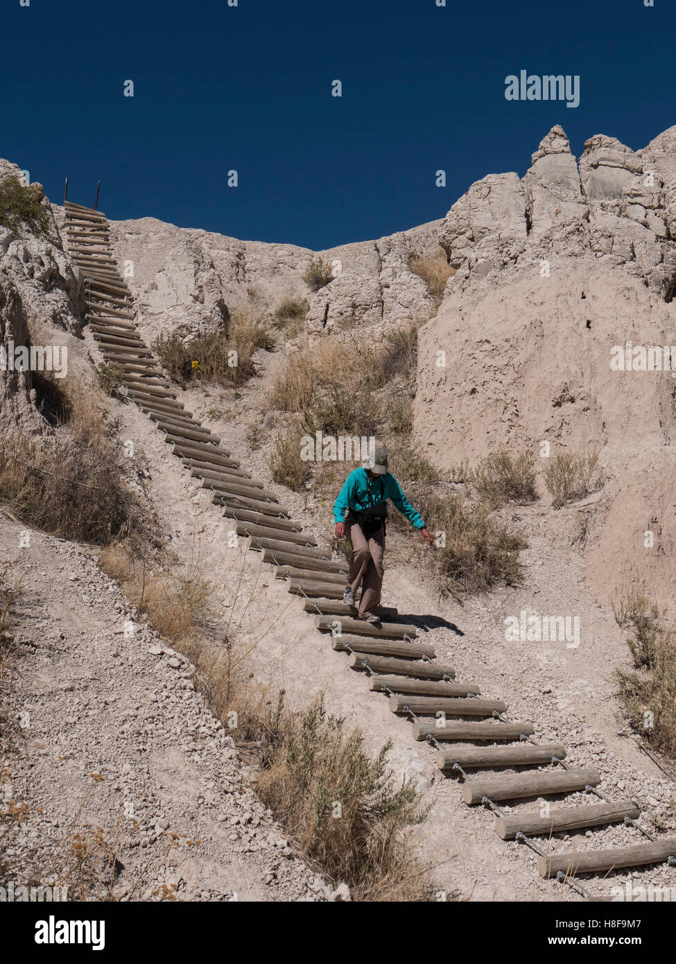 Woman descends the ladder, Notch Trail, Badlands National Park, South