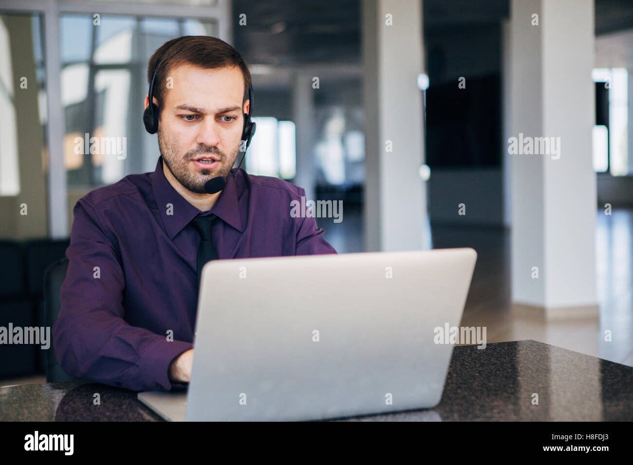 Focus on a joyful call centre agent with his headset Stock Photo