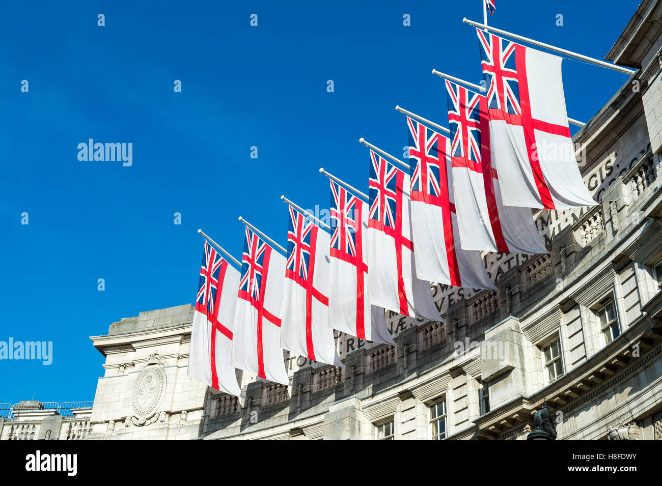 Traditional white ensign flags fly on Admiralty Arch, the ceremonial gateway between Trafalgar Square and The Mall in London, UK Stock Photo
