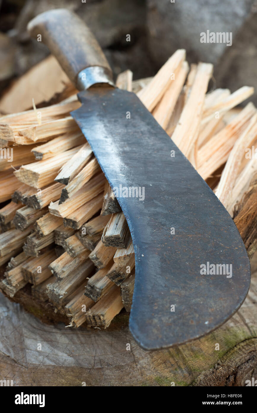 Closeup of a machete or billhook knife on a pile of sticks Stock Photo