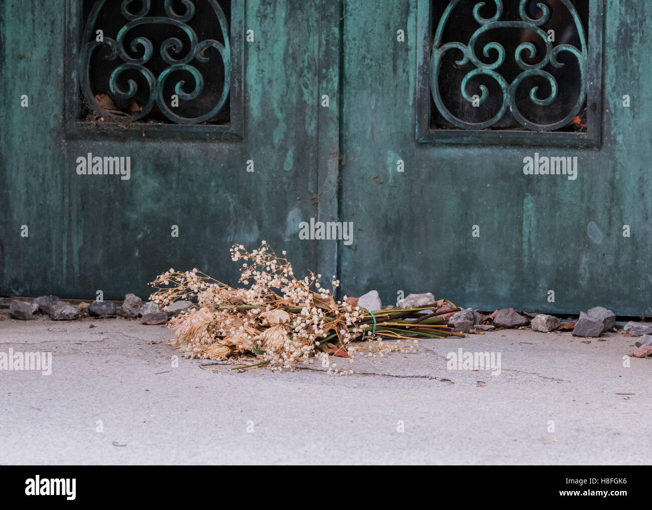 Dried Flowers At Tomb with copper patina door Stock Photo