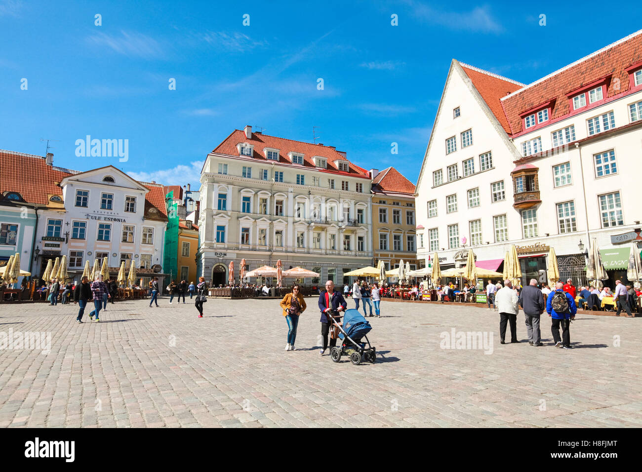 Tallinn, Estonia - May 2, 2016: Tourists and citizens walk on Town Hall square in old Tallinn, bright spring sunny day Stock Photo