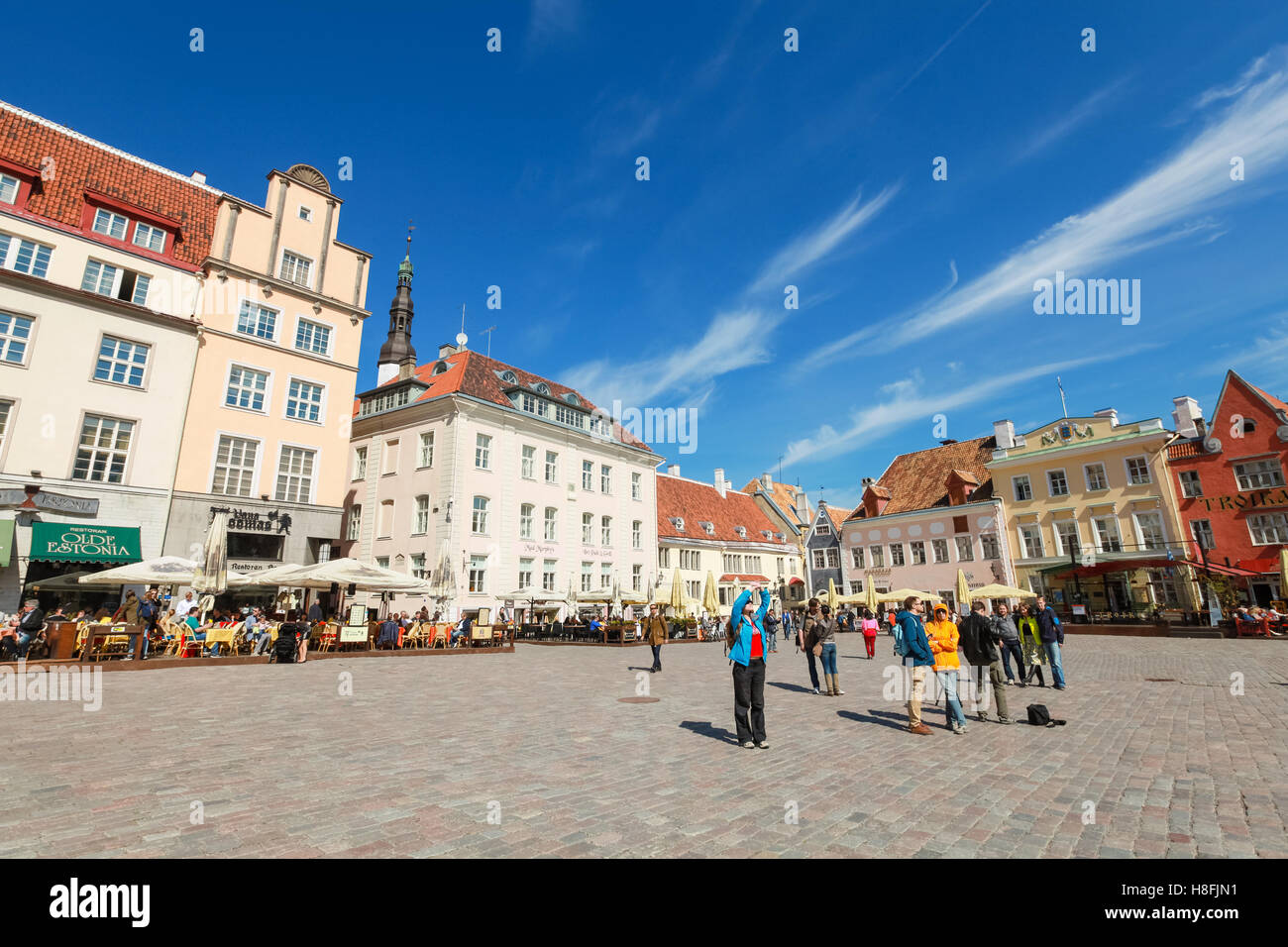 Tallinn, Estonia - May 2, 2016: Tourists walking on Town Hall square in old Tallinn, bright spring sunny day Stock Photo