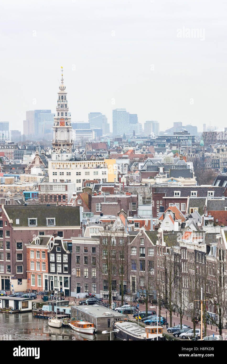 Amsterdam, Holland. Amsterdam city rooftops and Zuiderkerk church spire against modern buildings in the background. Stock Photo