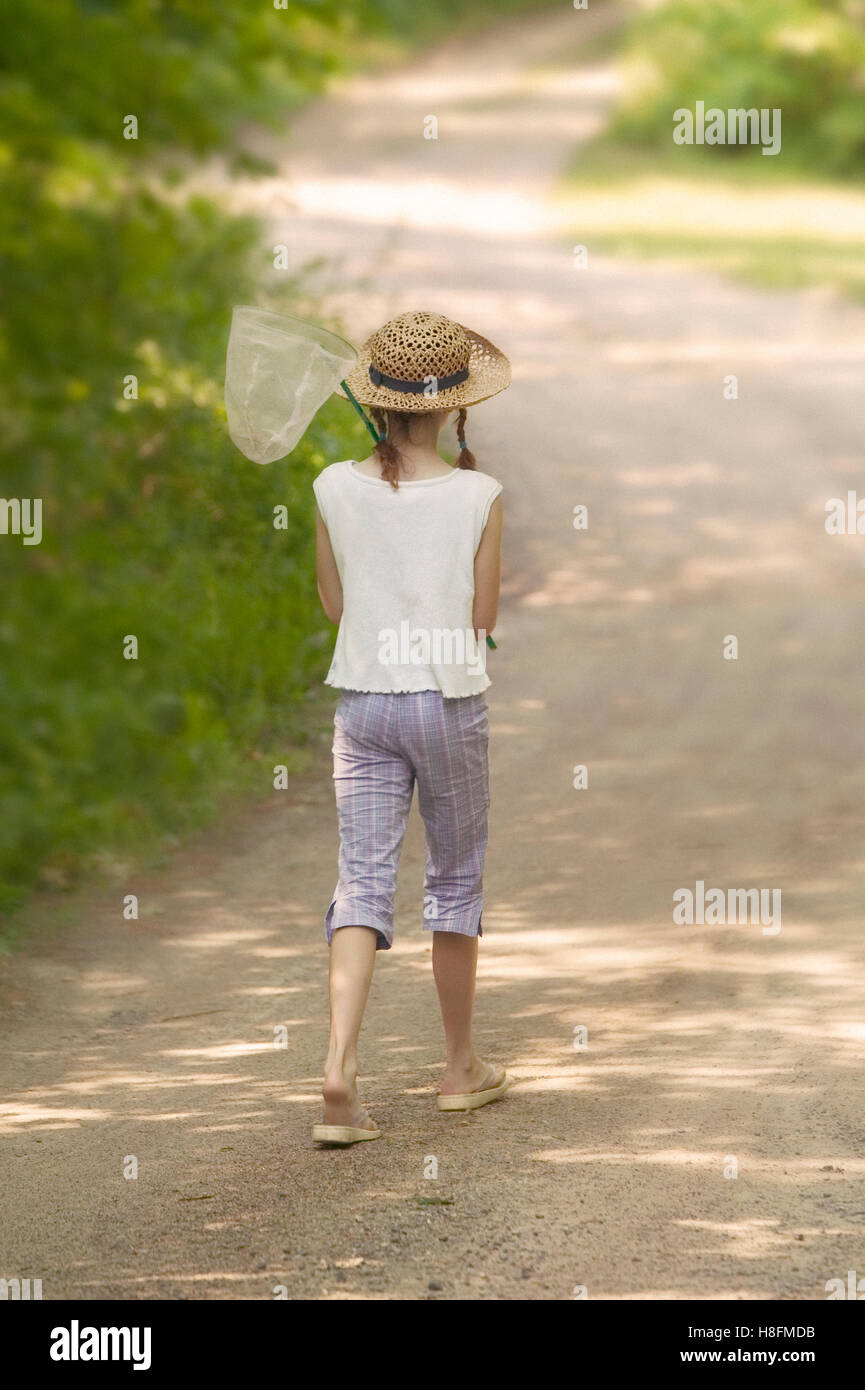 Young girl out for a walk looking at capture butterflies Stock Photo