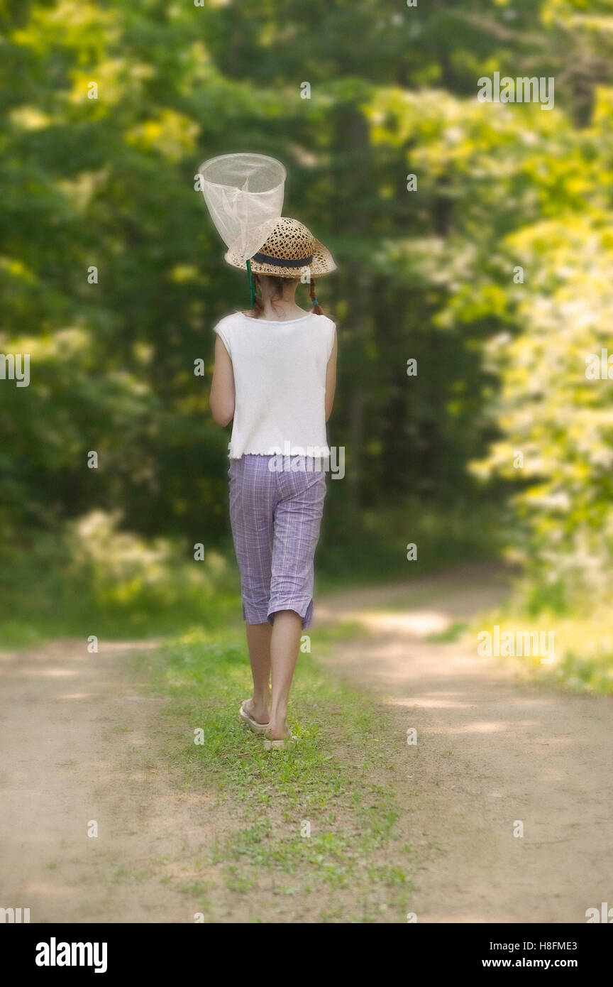 Young girl out for a walk looking at capture butterflies Stock Photo
