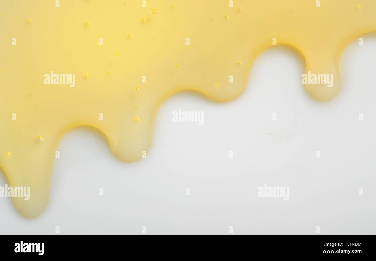 Honey liqiud flowing down on white background Stock Photo