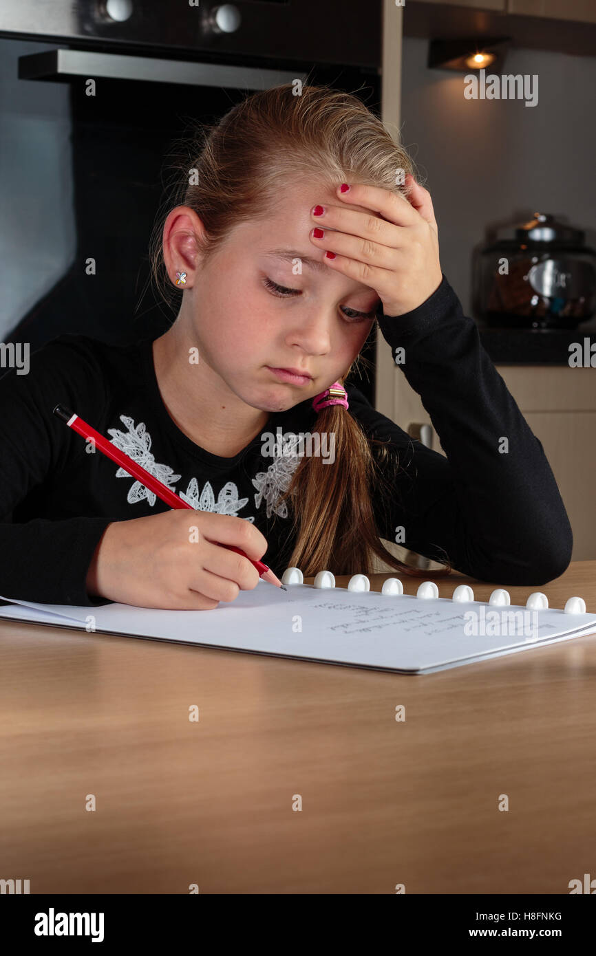Young girl doing homework at the kitchen table Stock Photo Alamy